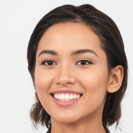 Joyful latino young-adult female with medium  brown hair and brown eyes