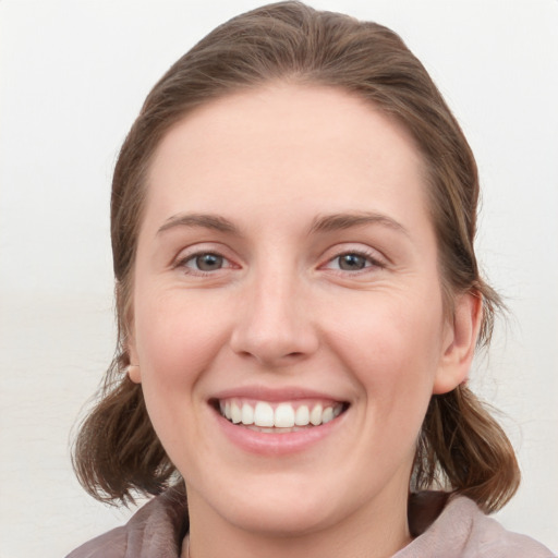 Joyful white young-adult female with medium  brown hair and blue eyes