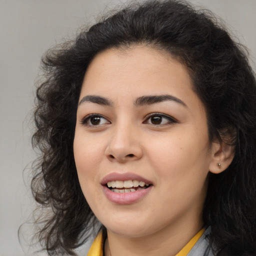 Joyful latino young-adult female with medium  brown hair and brown eyes