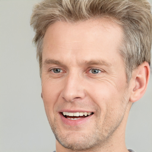 Joyful white adult male with short  brown hair and grey eyes