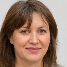 Joyful white adult female with long  brown hair and grey eyes