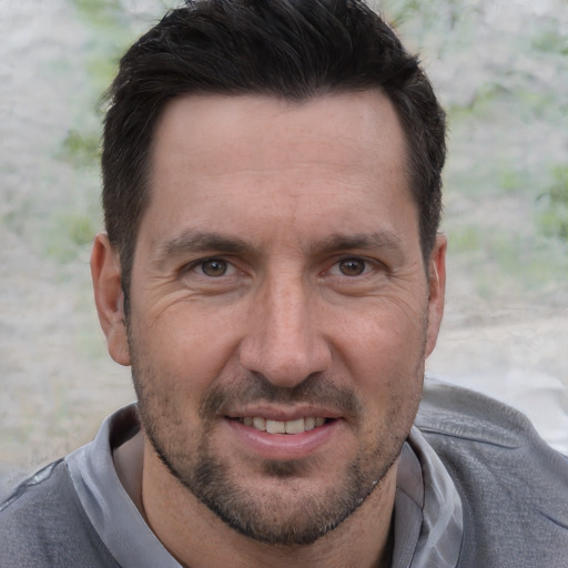 Joyful white adult male with short  brown hair and brown eyes