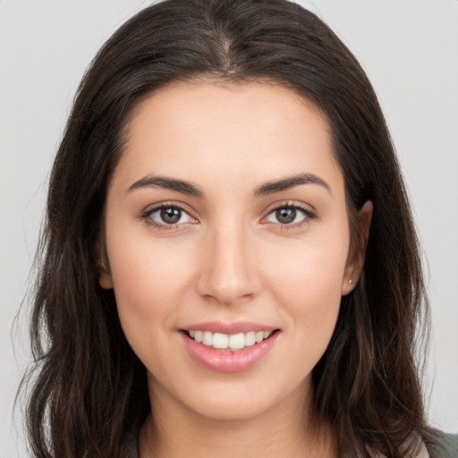 Joyful white young-adult female with long  brown hair and brown eyes