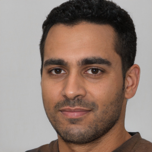 Joyful latino young-adult male with short  black hair and brown eyes