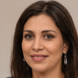 Joyful white adult female with long  brown hair and brown eyes