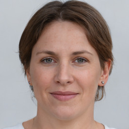 Joyful white adult female with medium  brown hair and grey eyes