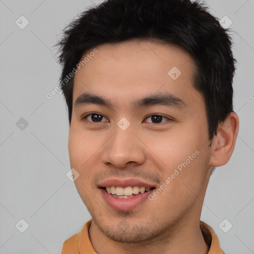 Joyful asian young-adult male with short  brown hair and brown eyes