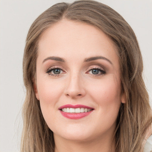 Joyful white young-adult female with long  brown hair and green eyes