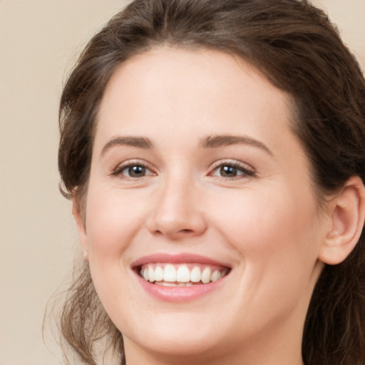 Joyful white young-adult female with long  brown hair and green eyes