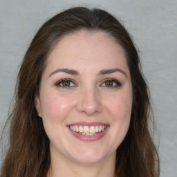 Joyful white young-adult female with long  brown hair and green eyes