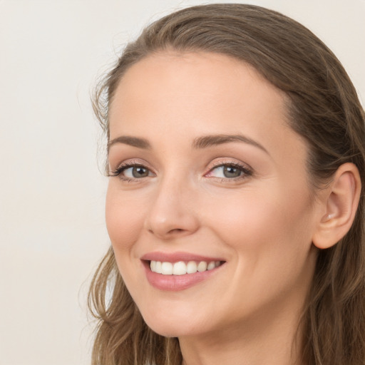 Joyful white young-adult female with long  brown hair and blue eyes