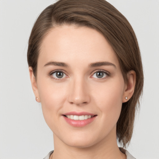 Joyful white young-adult female with medium  brown hair and grey eyes