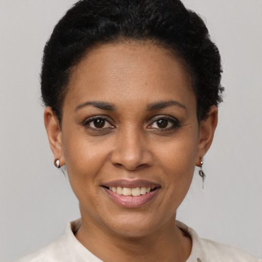 Joyful black young-adult female with short  black hair and brown eyes