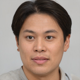 Joyful asian young-adult male with short  brown hair and brown eyes