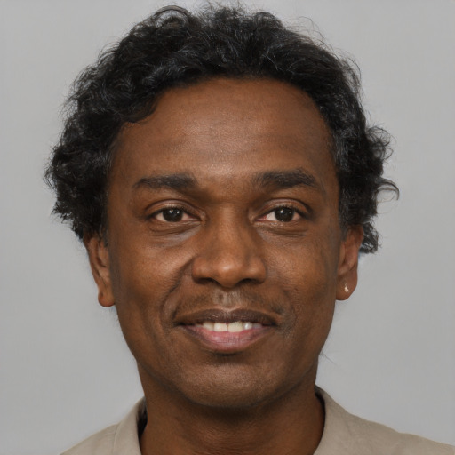 Joyful black adult male with short  black hair and brown eyes