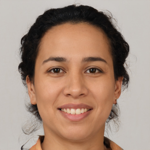 Joyful latino young-adult female with medium  brown hair and brown eyes