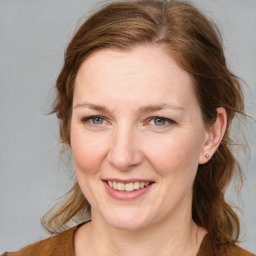 Joyful white adult female with medium  brown hair and blue eyes