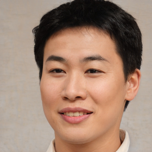Joyful asian young-adult male with short  brown hair and brown eyes