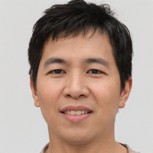Joyful asian young-adult male with short  brown hair and brown eyes