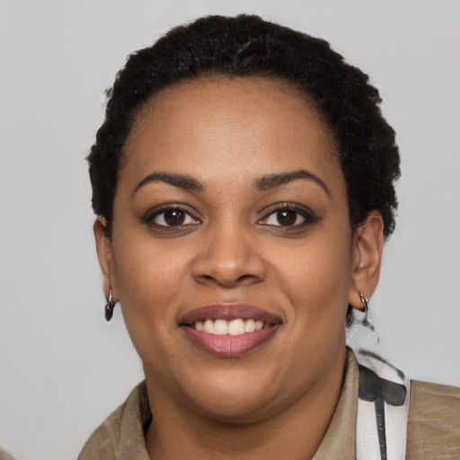 Joyful black young-adult female with short  black hair and brown eyes
