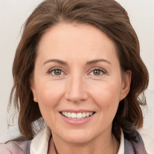 Joyful white adult female with medium  brown hair and grey eyes