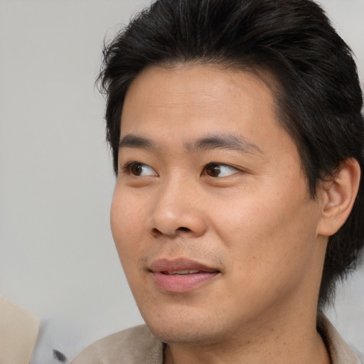 Joyful asian young-adult male with short  brown hair and brown eyes