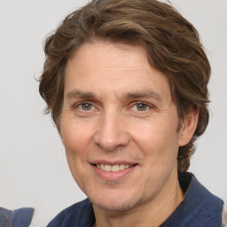 Joyful white adult male with medium  brown hair and grey eyes