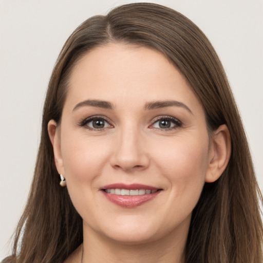 Joyful white young-adult female with long  brown hair and grey eyes