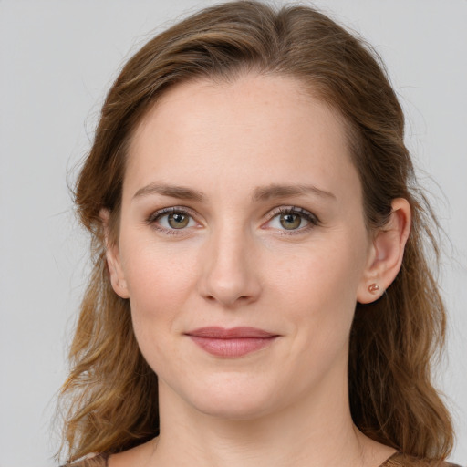 Joyful white young-adult female with long  brown hair and green eyes