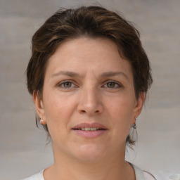 Joyful white adult female with medium  brown hair and grey eyes