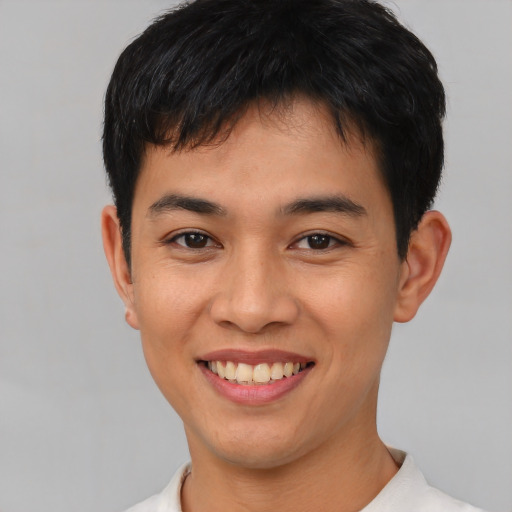 Joyful asian young-adult male with short  brown hair and brown eyes