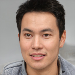 Joyful asian young-adult male with short  brown hair and brown eyes