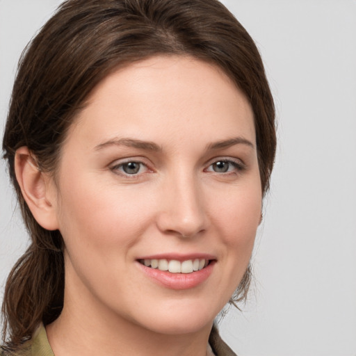 Joyful white young-adult female with medium  brown hair and grey eyes