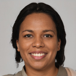 Joyful black adult female with medium  brown hair and brown eyes