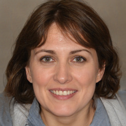 Joyful white adult female with medium  brown hair and brown eyes