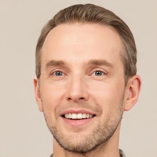 Joyful white young-adult male with short  brown hair and grey eyes