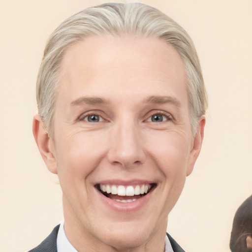 Joyful white adult male with short  blond hair and blue eyes