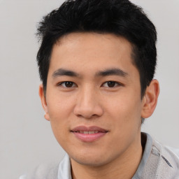 Joyful asian young-adult male with short  black hair and brown eyes