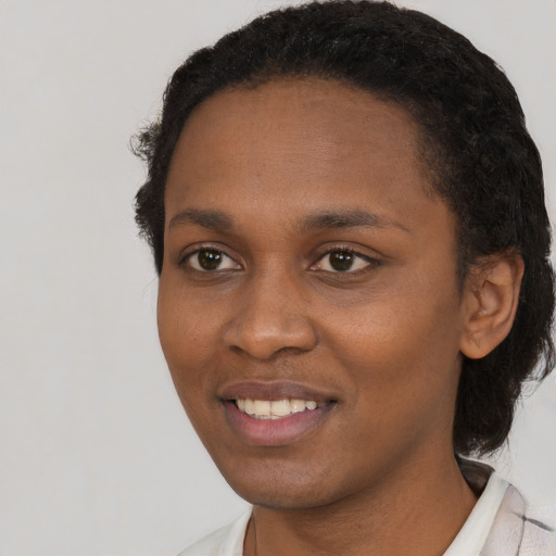 Joyful black young-adult female with short  black hair and brown eyes
