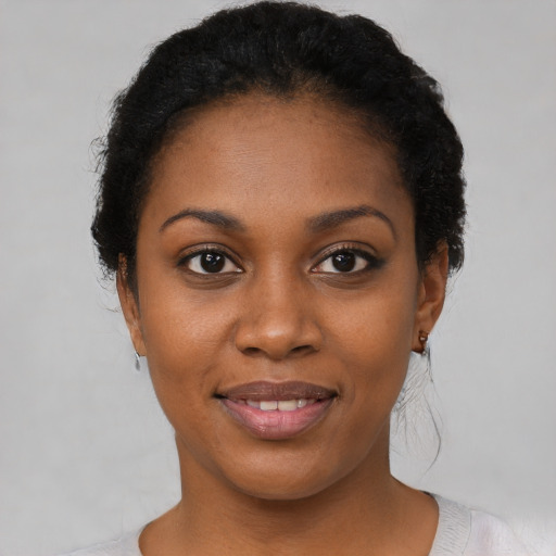 Joyful black young-adult female with short  black hair and brown eyes