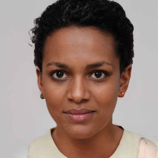 Joyful black young-adult female with short  black hair and brown eyes
