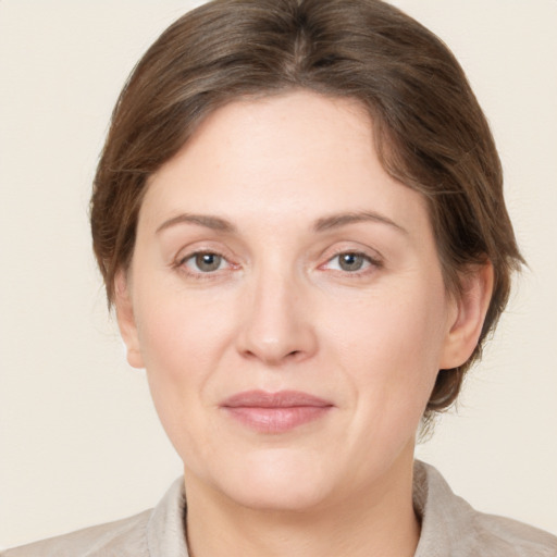 Joyful white adult female with medium  brown hair and grey eyes