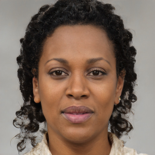 Joyful black young-adult female with long  brown hair and brown eyes