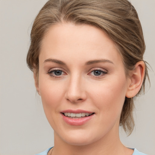 Joyful white young-adult female with medium  brown hair and grey eyes