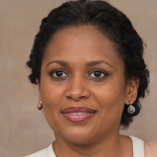 Joyful black adult female with medium  brown hair and brown eyes