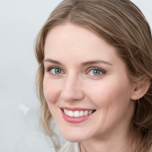 Joyful white young-adult female with medium  brown hair and blue eyes