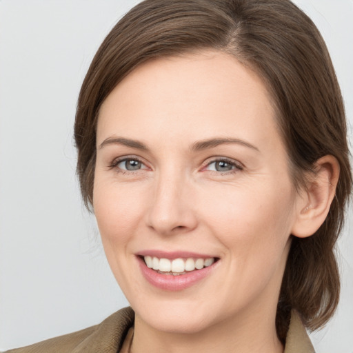 Joyful white young-adult female with medium  brown hair and grey eyes