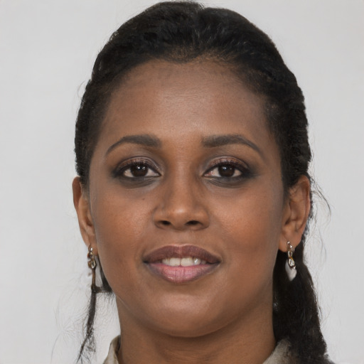 Joyful black young-adult female with long  brown hair and brown eyes