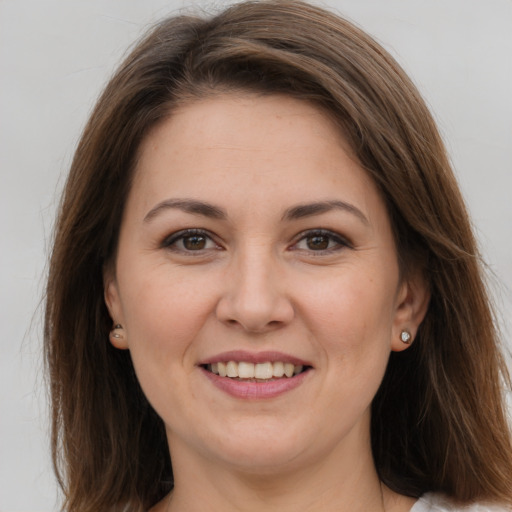 Joyful white young-adult female with long  brown hair and brown eyes