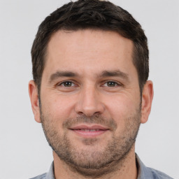 Joyful white young-adult male with short  brown hair and brown eyes